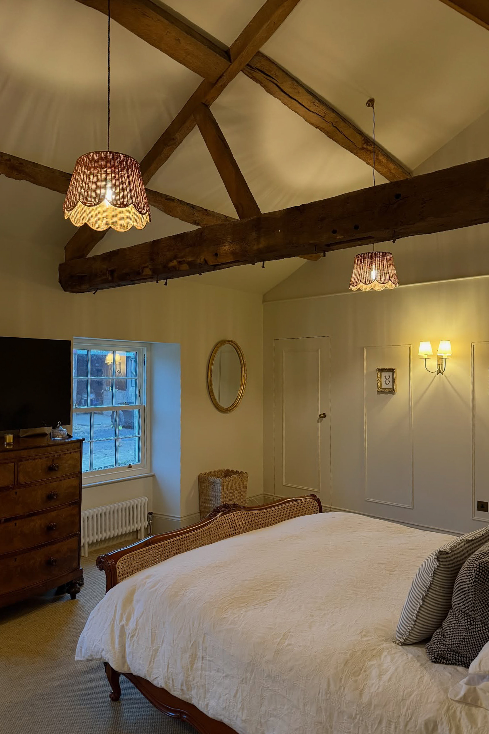 Vaulted bedroom ceiling with exposed oak trusses in renovated farmhouse